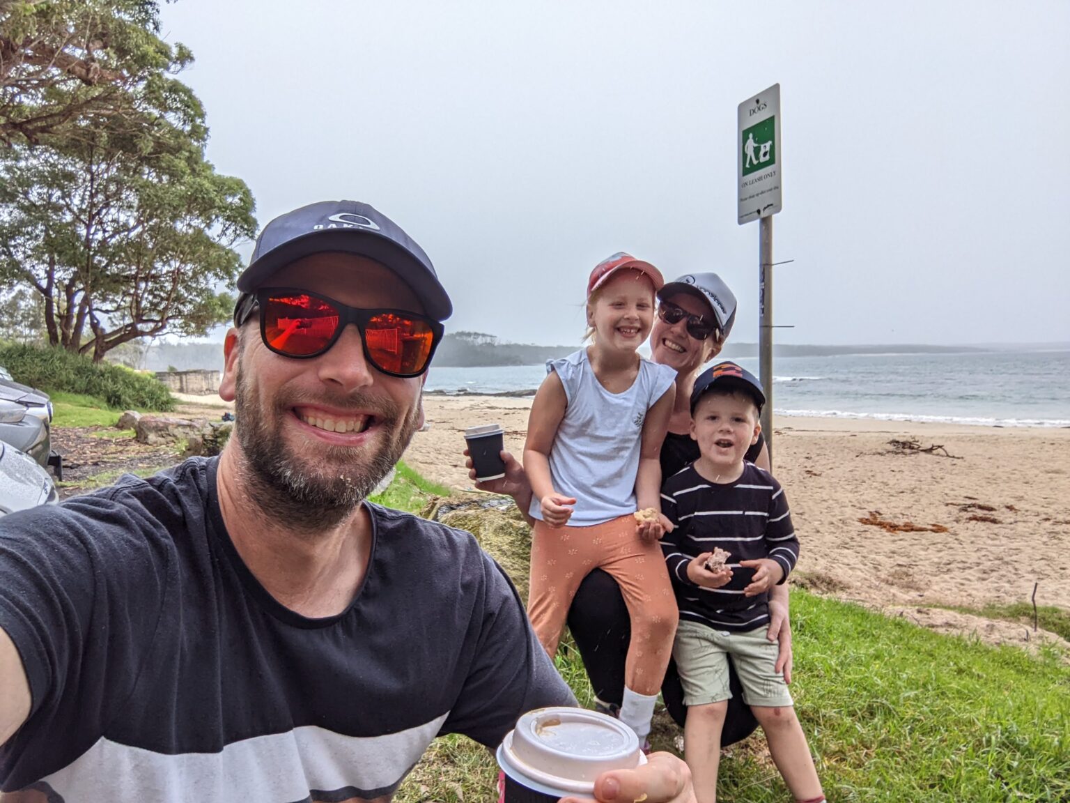 Ola Halvorsen with his wife and two kids on an overcast beach, holding coffee cups